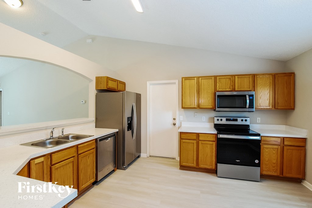 a kitchen with wooden cabinets and stainless steel appliances