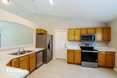 a kitchen with wooden cabinets and stainless steel appliances