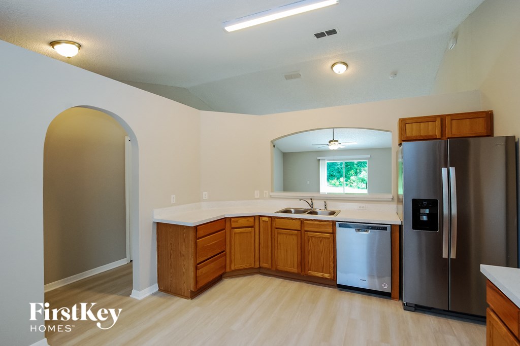 a kitchen with wooden cabinets and a stainless steel refrigerator