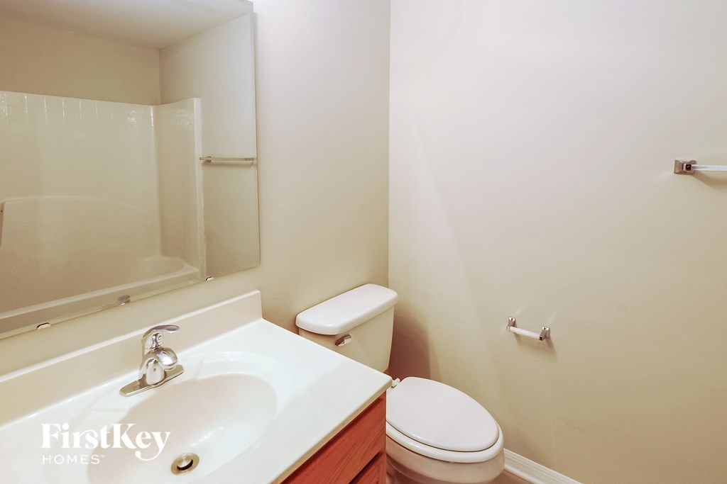 a bathroom with a sink toilet and a mirror