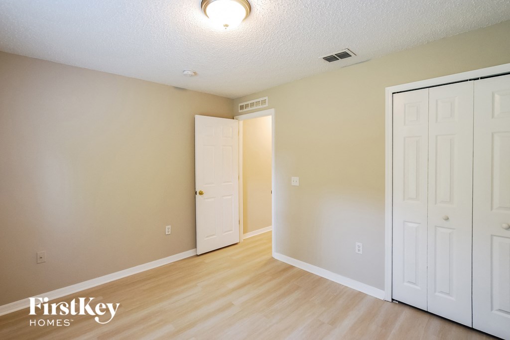 a bedroom with two closets and a door to a hallway