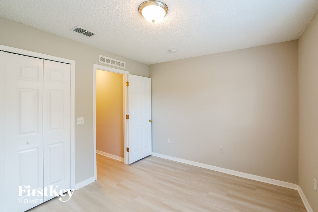 a living room with a door to a hallway and a door into a bedroom