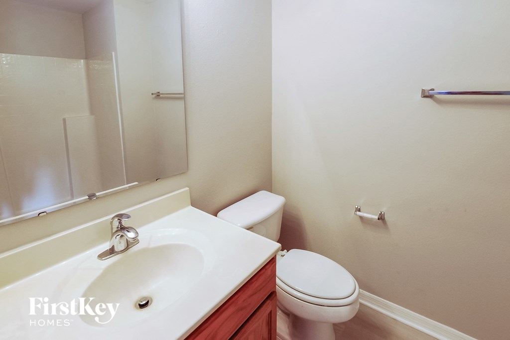 a bathroom with a sink toilet and a mirror