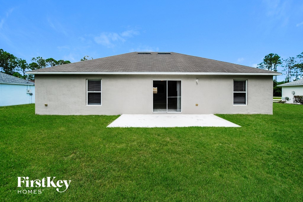 a small white house with a yard and a white driveway