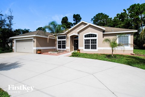 a beige house with a driveway in front of it