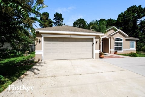 a white garage door on a driveway in front of a house