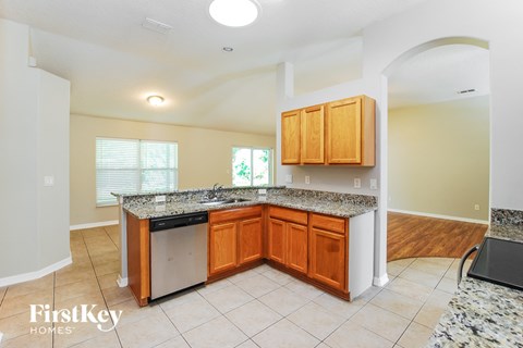 a kitchen with granite counter tops and wooden cabinets