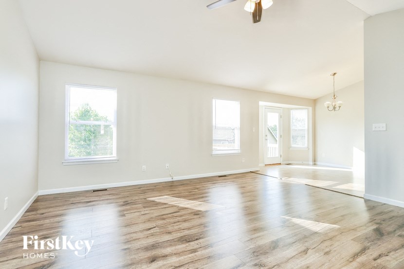 an empty living room with white walls and wood floors