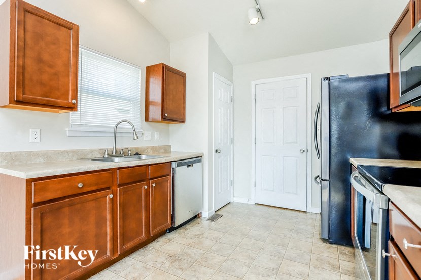 a kitchen with wooden cabinets and a black refrigerator