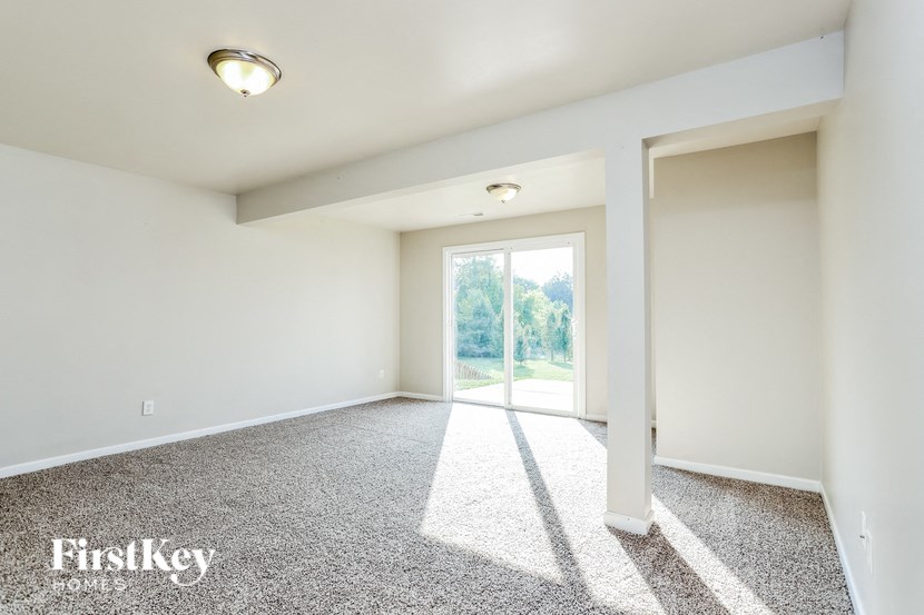 an empty living room with a door to a patio