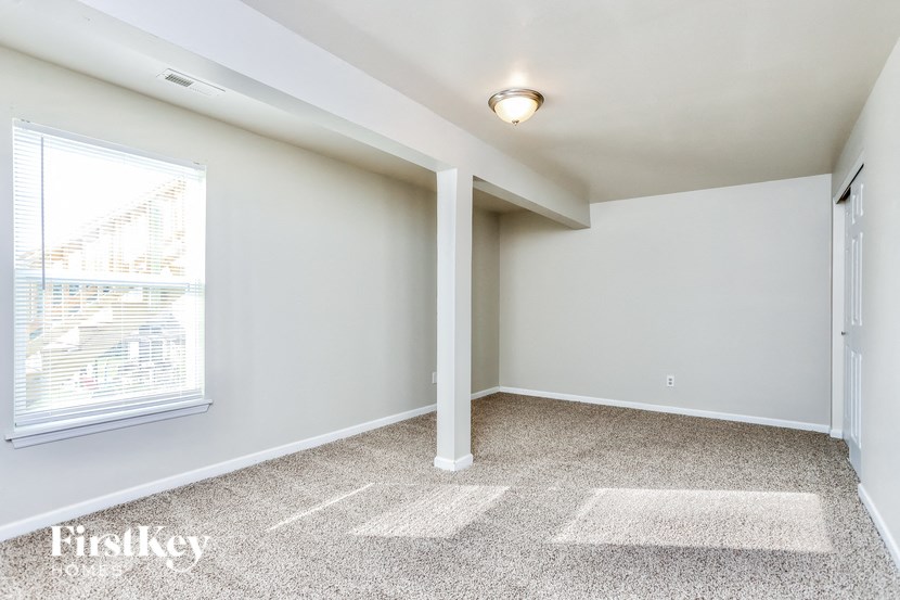 an empty room with a large window and white walls