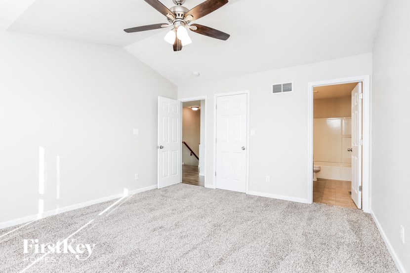 a empty living room with a ceiling fan and a rug
