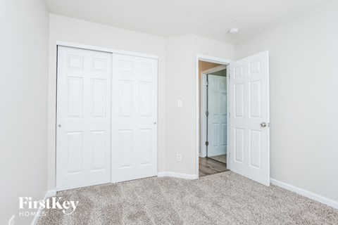 a bedroom with two closets and a door to a hallway