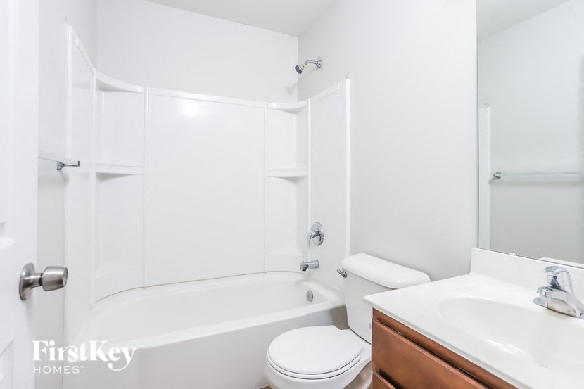 a white bathroom with a tub sink and toilet