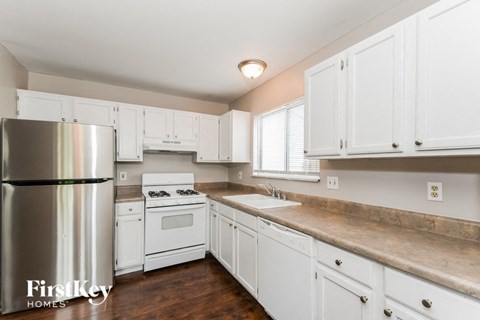 A kitchen with white cabinets and a stainless steel refrigerator.