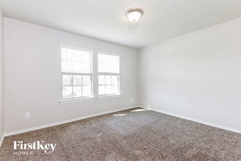 a bedroom with a carpeted floor and two windows