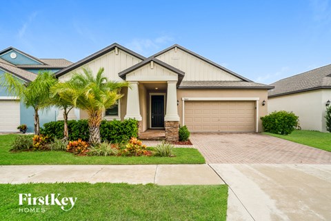 A house with a garage and a driveway in front of it.
