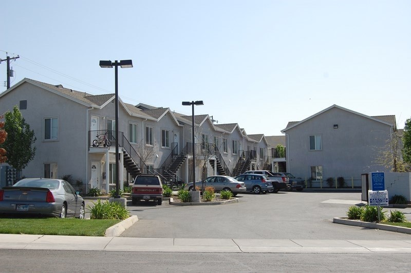 a row of houses with cars parked in a parking lot