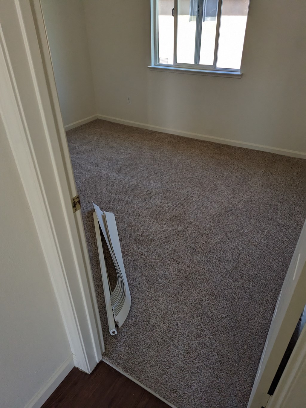 an empty room with a door open and a heater on the floor