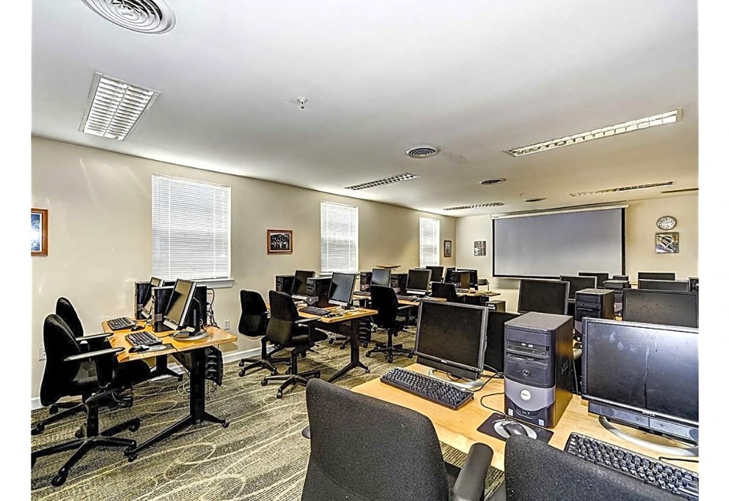 a classroom with computers and chairs in a room