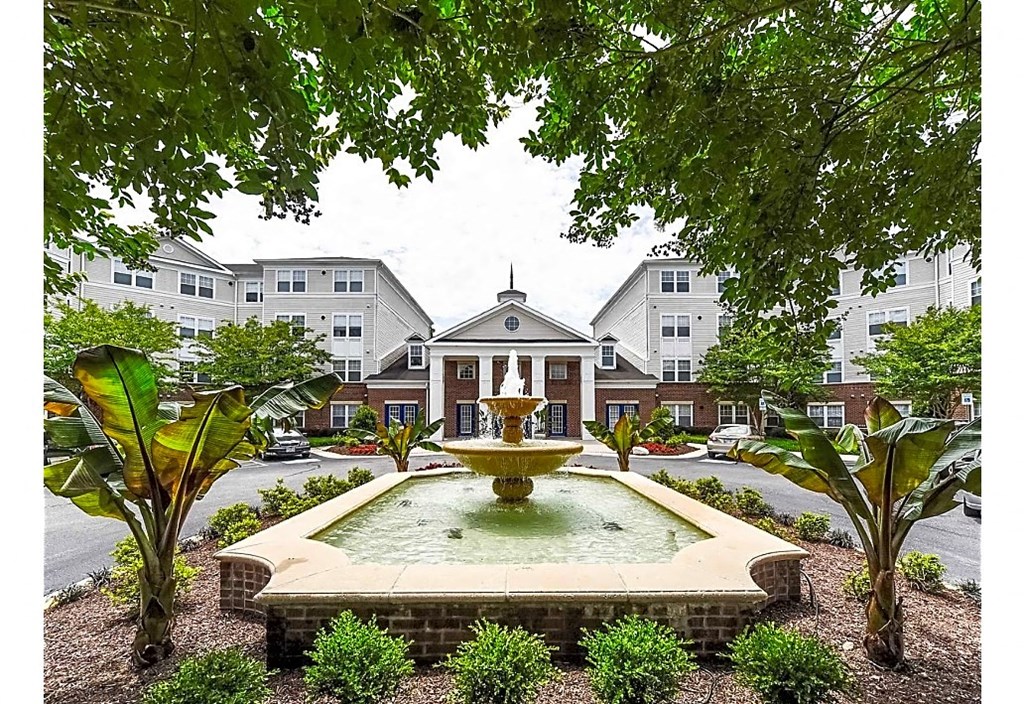 a fountain in the middle of a courtyard in front of a building
