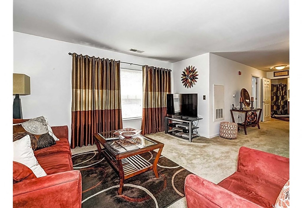 a living room with red furniture and a tv