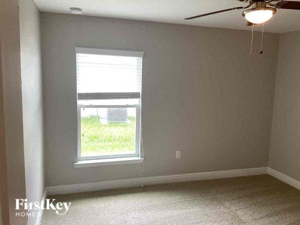an empty room with a window and a ceiling fan
