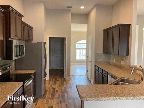a kitchen with stainless steel appliances and wooden floors