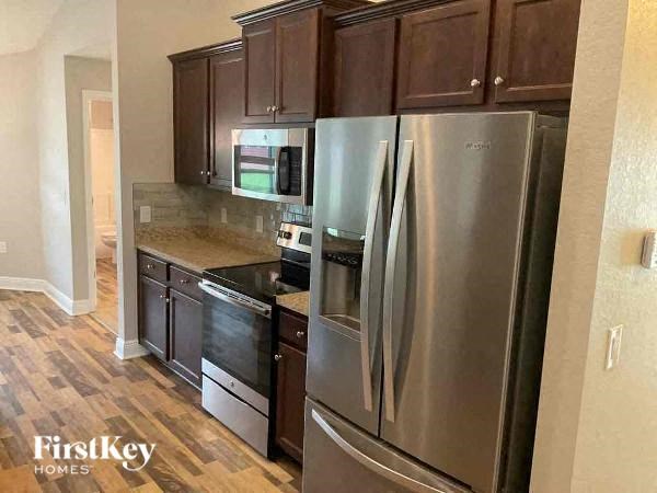 a kitchen with stainless steel appliances and wooden floors