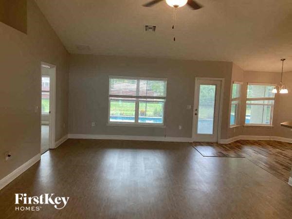 an empty living room with a ceiling fan