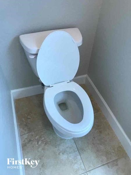 a white toilet in a bathroom with the seat up