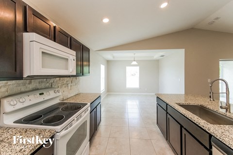 a kitchen with a stove and a sink and a microwave
