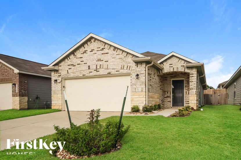 A house with a garage and a driveway in front of it.