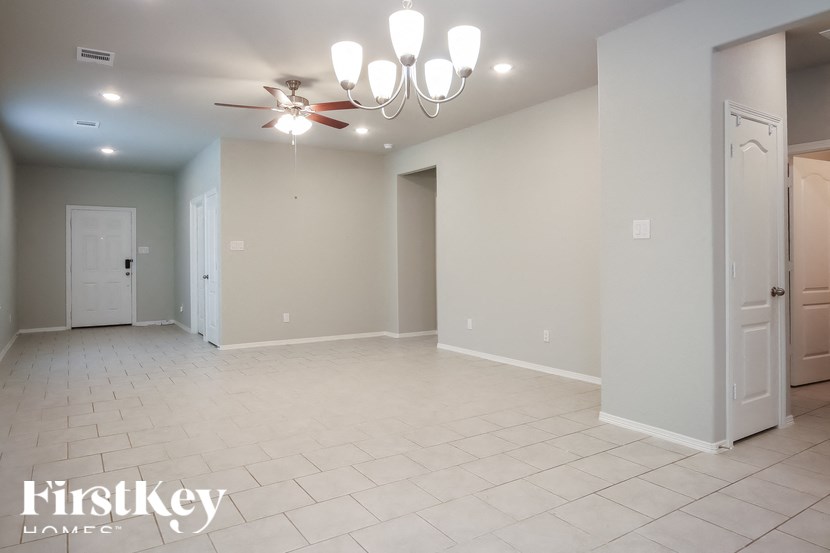 A spacious room with a chandelier and a ceiling fan.