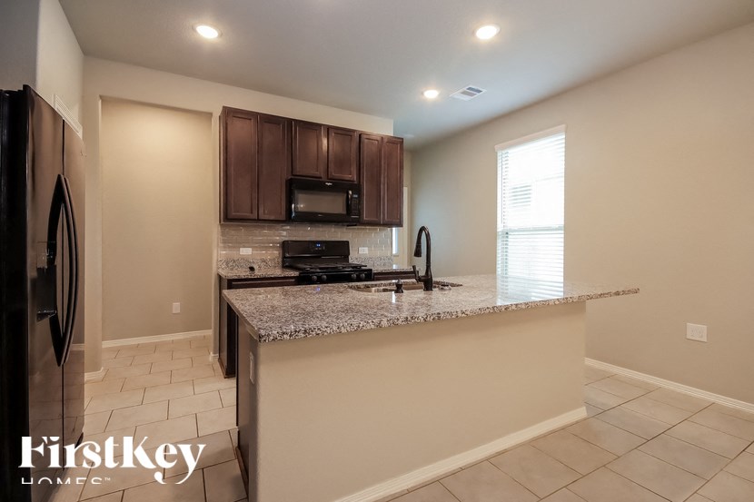 A kitchen with a granite countertop and a refrigerator.