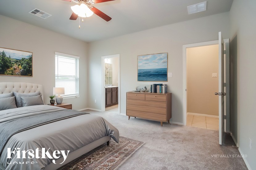 A bedroom with a large bed, a dresser, and a painting on the wall.