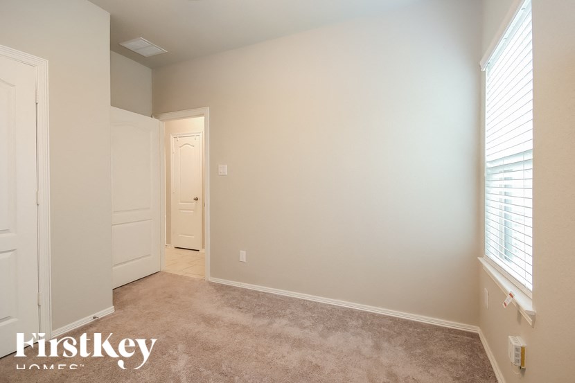 A room with a carpeted floor and a doorway leading to another room.