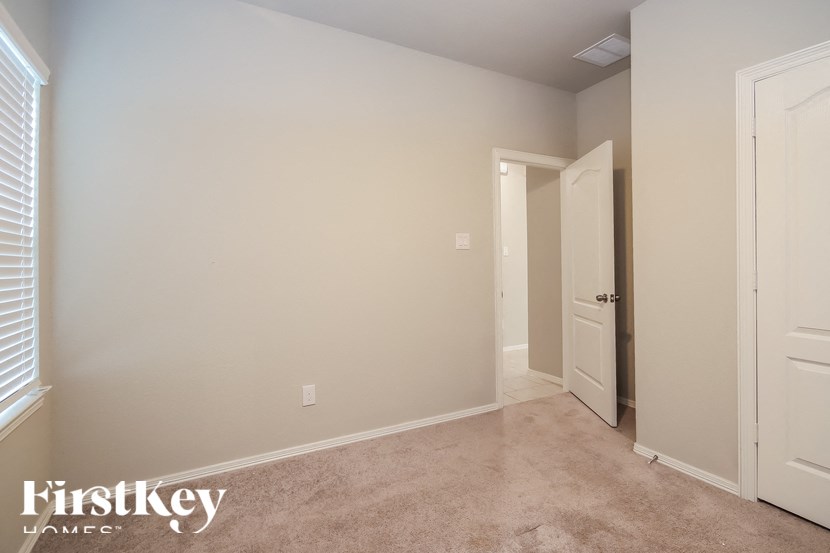 A room with a carpeted floor and a white door.