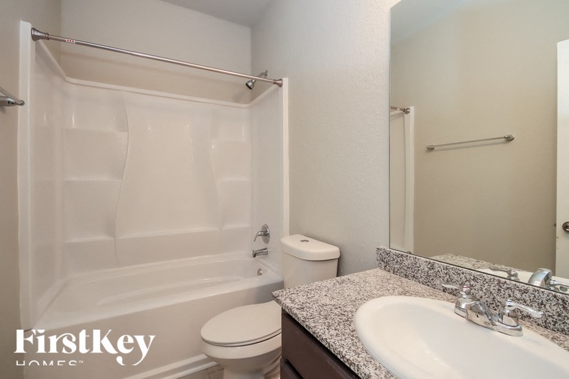 A white bathroom with a toilet, sink, and bathtub.