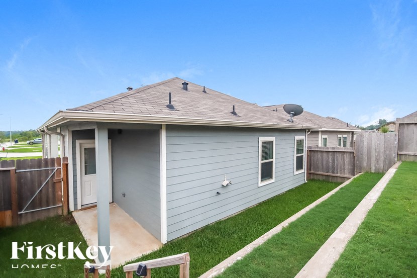 A house with a grey siding and a brown roof is for sale.