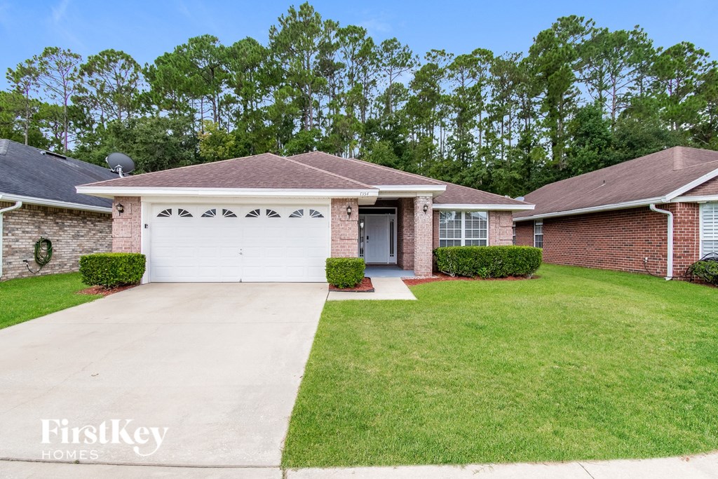 a brick house with a white garage door and a lawn