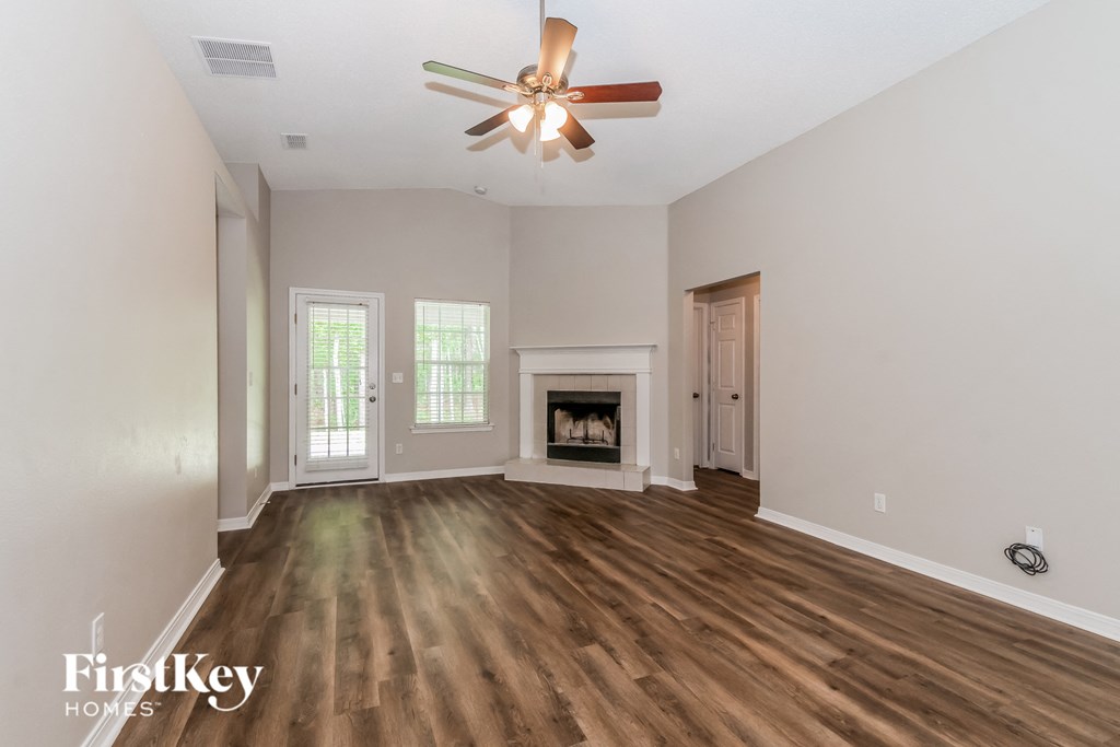 a living room with a ceiling fan and a fireplace
