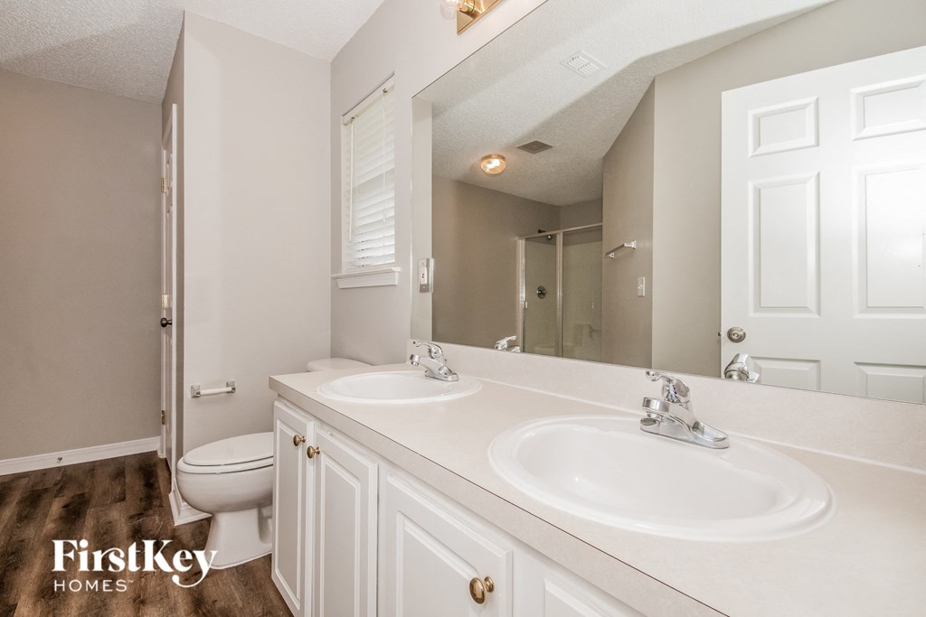 a bathroom with two sinks and a toilet and a mirror