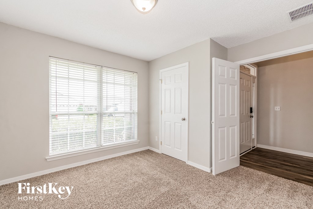 a bedroom with a door to a closet and a window