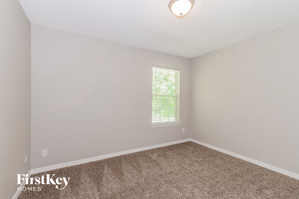 a bedroom with a carpeted floor and a window