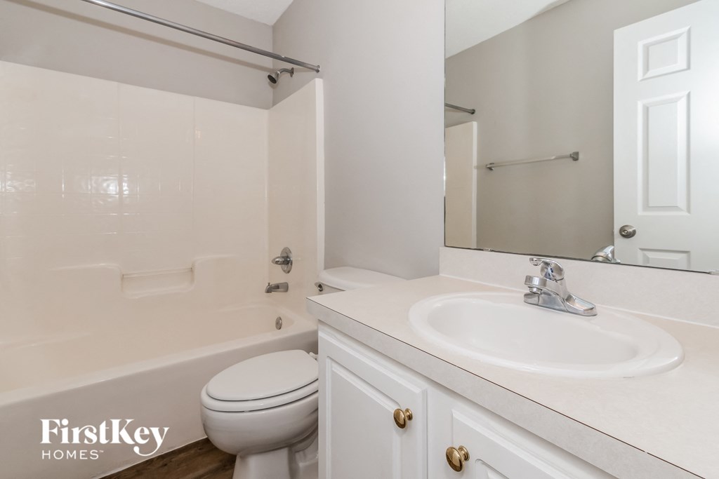 a bathroom with a sink toilet and a mirror