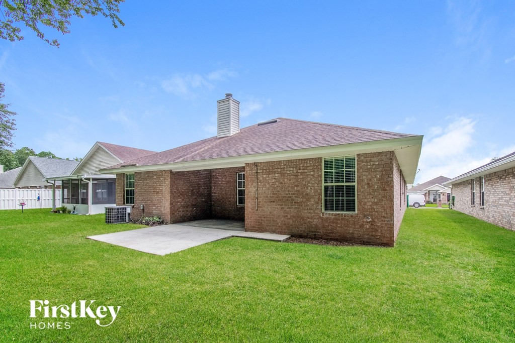 a brick house with a lawn and a patio