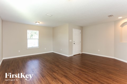 a living room with wood floors and a white door