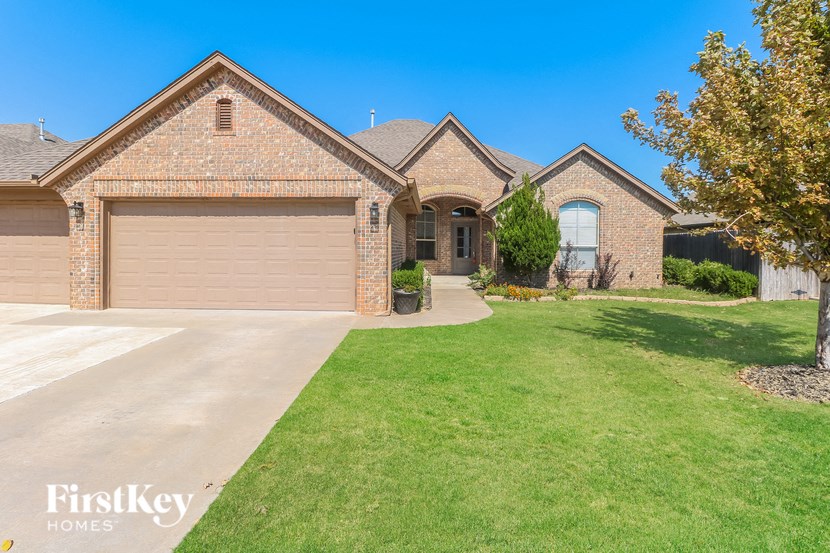 a large brick house with a garage and a lawn