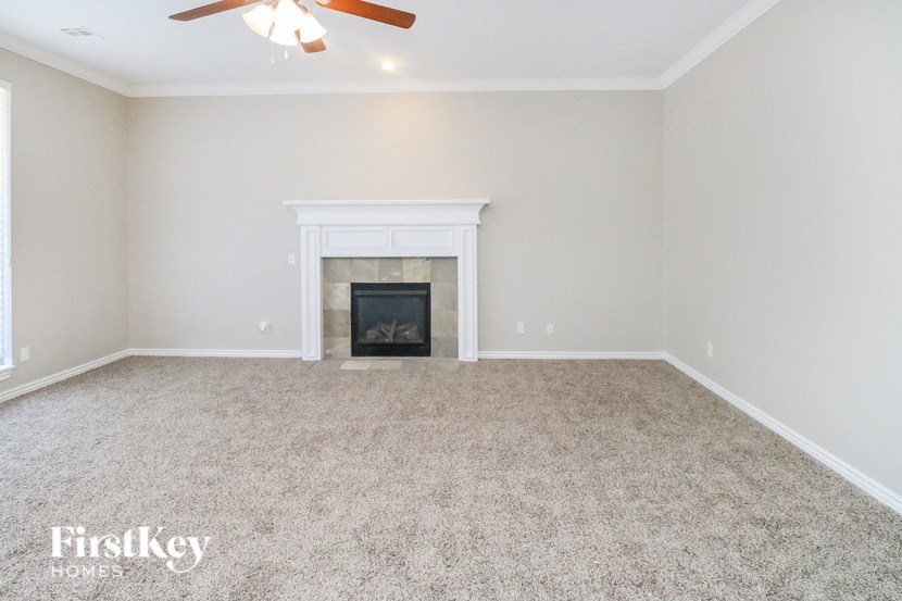 the living room has a fireplace and carpeted flooring